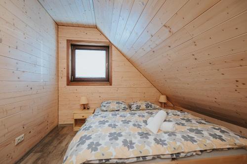 a bedroom with a bed in a wooden cabin at Gazdov dvor in Dolný Kubín