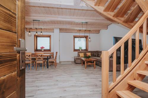 a dining room and living room with wooden ceilings at Gazdov dvor in Dolný Kubín
