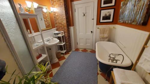 a bathroom with a sink and a toilet and a tub at The Lark & Loon Inn in Annapolis Royal