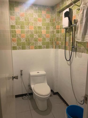 a bathroom with a toilet and a shower at Lola Flor's Guest House in El Nido