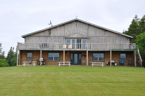a large wooden house with two benches in front of it at Powley's Wild Goose Lodge in Stanley Bridge