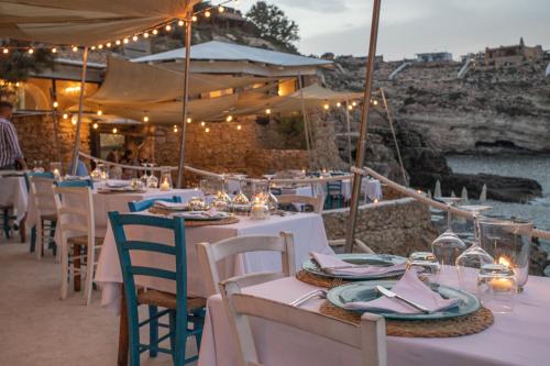 a restaurant with tables and chairs with a view of the water at Relais Isole del Sud in Lampedusa