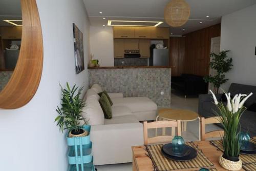 ein Wohnzimmer mit einem weißen Sofa und einem Tisch in der Unterkunft appartement de luxe front mer à DAR BOUAAZA in Dar Bouazza