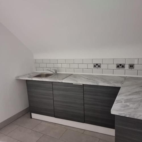 a kitchen with a sink and a counter at Prescot Rooms in Liverpool