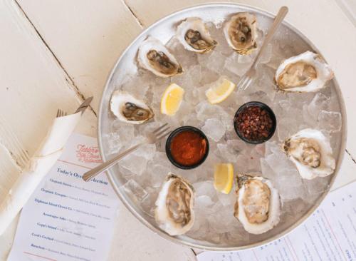 a plate of oysters on top of a table at Wylder Hotel - Tilghman Island in Saint Michaels