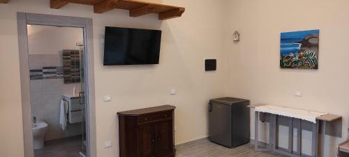 a bathroom with a flat screen tv on the wall at Camera Nta Cantunera in San Biagio