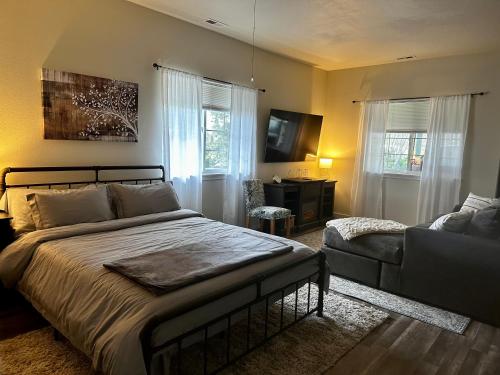 Sonia's Guest Suite in Montesano-Gateway to Olympic National Park في Montesano: غرفة نوم بسرير واريكة
