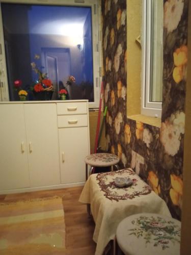 a kitchen with a table and two stools and a window at Apartamentai in Tauragė