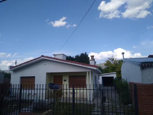 una casa blanca con una valla delante en Chalet los Abuelos en La Falda