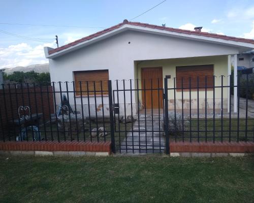 una pequeña casa blanca con una valla negra en Chalet los Abuelos en La Falda