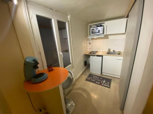 - une petite cuisine avec une petite table et un comptoir dans l'établissement Naranjas - Fibre Wi fi - Centre ville, à Troyes
