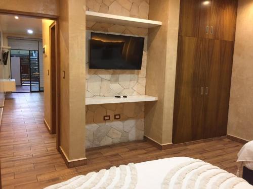 a bedroom with a bed and a tv on a wall at New apartment with all services and pool Marcos #1 in Isla Mujeres