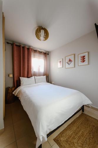 a large white bed in a bedroom with a window at Le Petit Jardin #2 in Volos