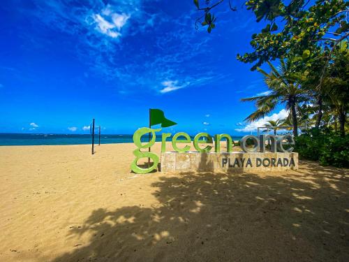 a sign on a beach with the ocean and the sky at Xeliter Green One Playa Dorada in San Felipe de Puerto Plata