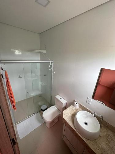 a bathroom with a toilet and a sink and a shower at Hotel Pousada Posto Carvalho in Campo Formoso