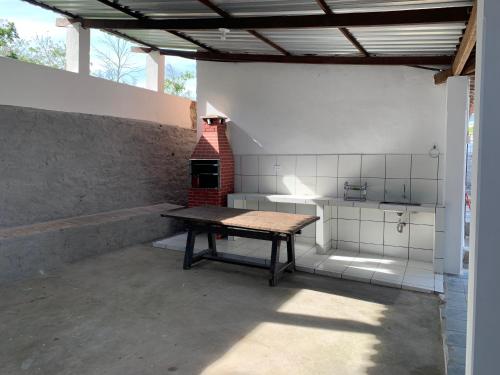 een patio met een tafel en een bakstenen oven bij Casa do Vale in Triunfo