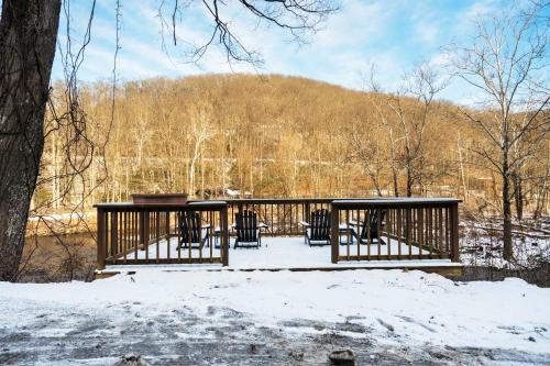 a deck with chairs and a table in the snow at River Front Resort in Elkins
