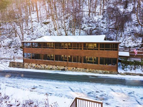 a building covered in snow with a snow covered ground at River Front Resort in Elkins