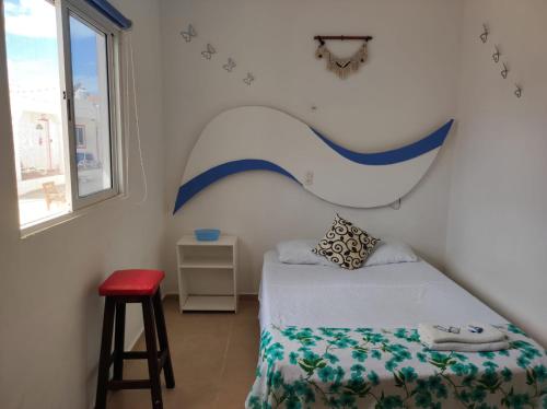 a bedroom with a bed and a red stool at Squalo's Place in Holbox Island