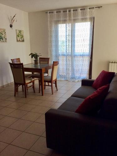 a living room with a couch and a table and chairs at La casa di Armando in San Gemini