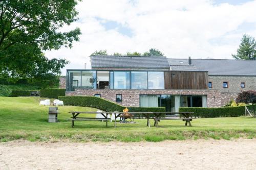una casa en la playa con dos mesas de picnic en Vakantiewoningen Hoeve Carpe Diem - Dalhem - Aubel - Voeren en Dalhem