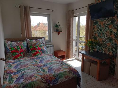 a bedroom with a bed with a view of a balcony at TOPOLA in Gąski