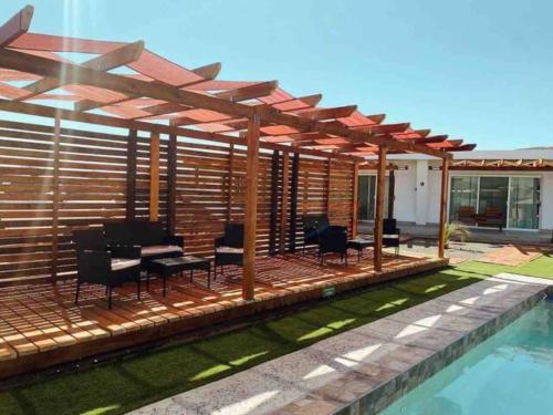 a deck with a table and chairs next to a pool at Quintas Marlet en la ruta del vino in Ensenada