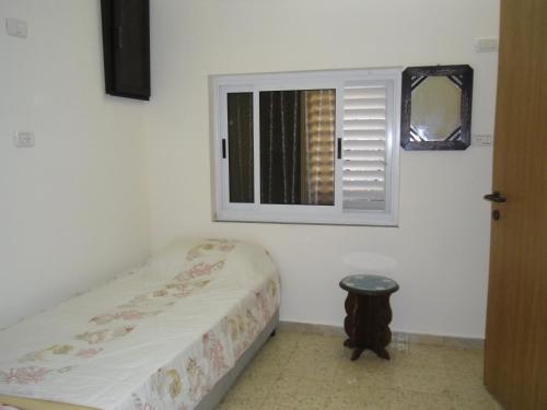 a small bedroom with a bed and a window at Cana Wedding Guest House in Kafr Kannā