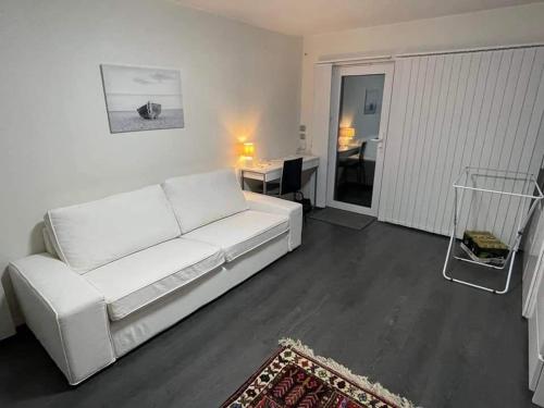 un sofá blanco en una sala de estar con mesa en ÖLJERSJÖ COTTAGE en Lyckeby