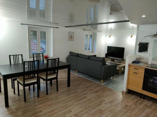 salon ze stołem i kanapą w obiekcie A la porte des vosges w mieście Raon-lʼÉtape