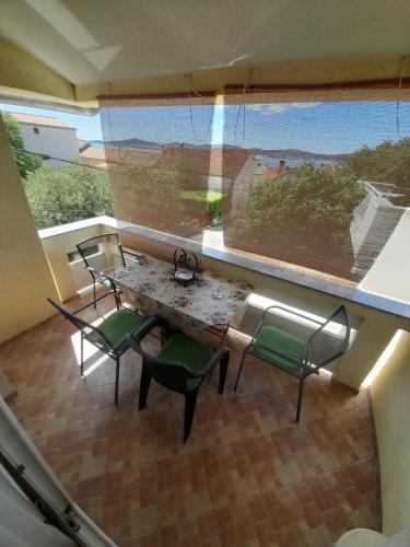 - une table et des chaises dans une chambre avec fenêtre dans l'établissement Apartment Dukic, à Sveti Filip i Jakov