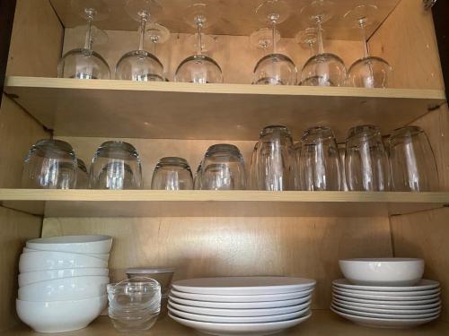 a shelf filled with glasses and plates and bowls at ,Treasure Cay, Bahamas, Cottages Luis & Sofia, 2 Bed 2 Bath in Treasure Cay