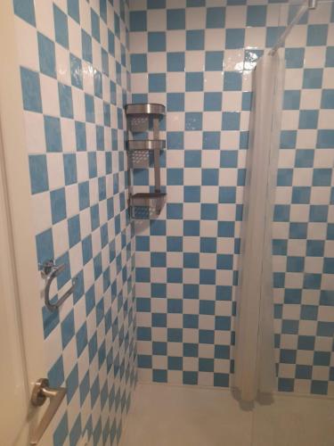 a bathroom with a shower with a checkered wall at Beachfront House in Málaga