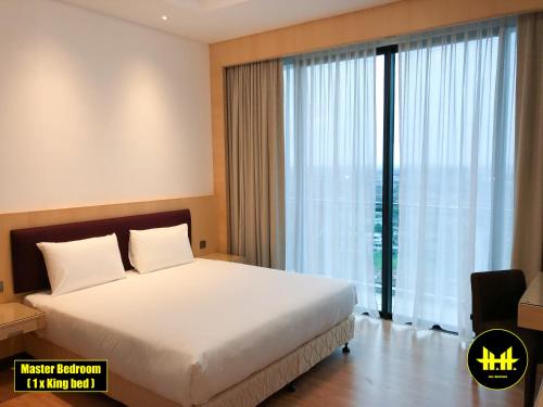 a bedroom with a large bed and a large window at VACA Apartments at Imperial Suites in Kuching