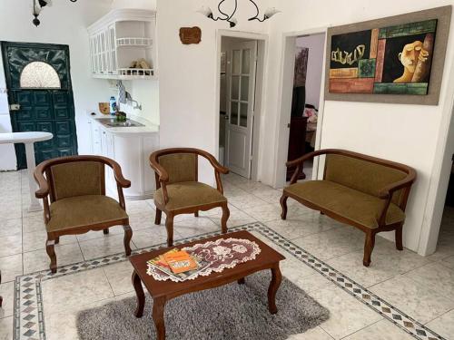 sala de estar con 2 sillas y mesa de centro en Casa de Campo Nuestra Tierra, en Quito