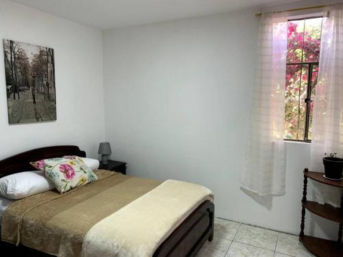 1 dormitorio con cama y ventana en Casa de Campo Nuestra Tierra, en Quito