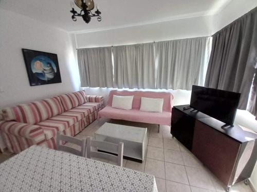 a living room with a couch and a table at Kardamena Holiday Apartments in Kardamaina