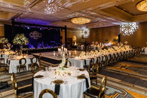 a banquet hall with white tables and chairs at Fairmont Scottsdale Princess in Scottsdale