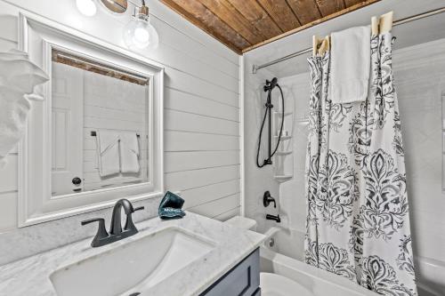 a white bathroom with a sink and a shower curtain at Sky View Mountain Dream in Gatlinburg