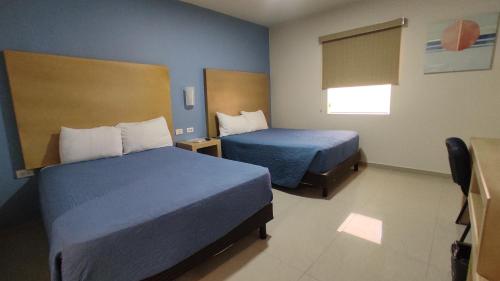 Habitación de hotel con 2 camas y ventana en Capital Hotel en Monclova