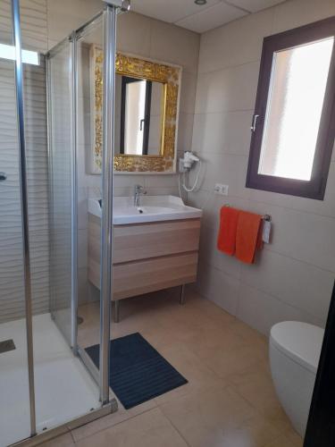 uma casa de banho com um chuveiro, um lavatório e um WC. em Apartamento con terraza y jardín em Las Breñas