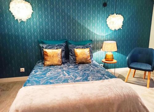 um quarto com uma cama e uma parede azul em Studio confort la plume em Pont-sur-Seine