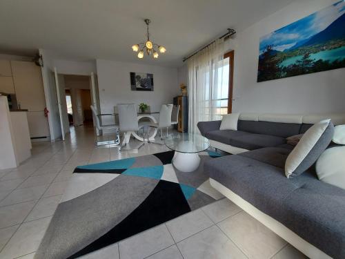 a living room with a couch and a table at Au cœur de St Jorioz, spacieux appartement avec terrasse et vue montagne. in Saint-Jorioz