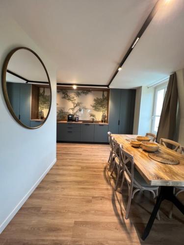 une salle à manger avec une table et un miroir dans l'établissement DUPLEX AVENUE ROYALE, à Compiègne