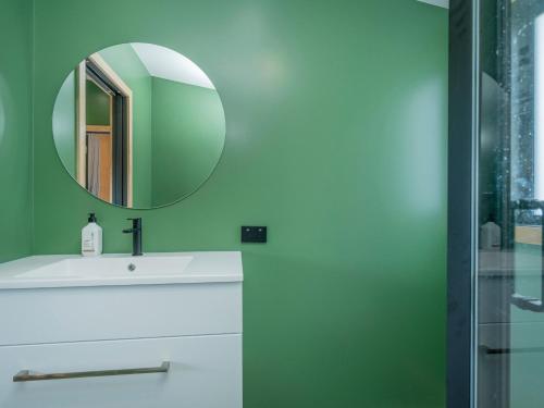 a bathroom with a white sink and a mirror at The Little Bach at Whangapoua in Whangapoua