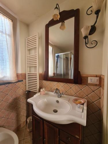 La salle de bains est pourvue d'un lavabo et d'un miroir. dans l'établissement Residenza Maria Letizia, à Milo