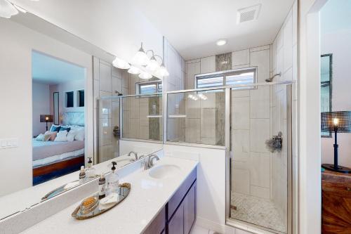 Un baño con lavabo y ducha y una cama. en Getaway in the Sun, en Flagstaff