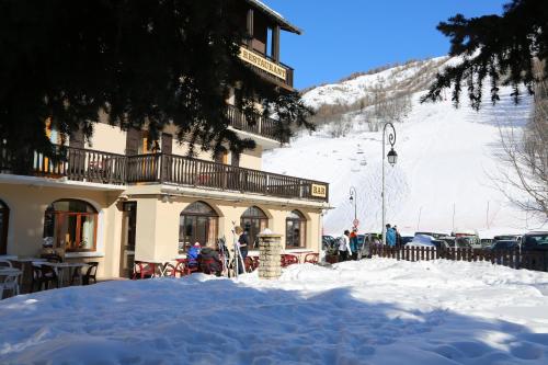 a building in the snow with people standing outside at Le Relais du Galibier in Valloire