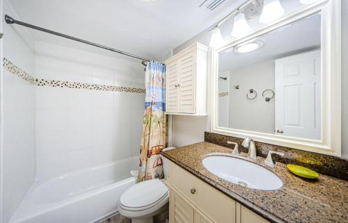 a bathroom with a sink and a toilet and a tub at Beachfront Aldea 5 in Clearwater Beach