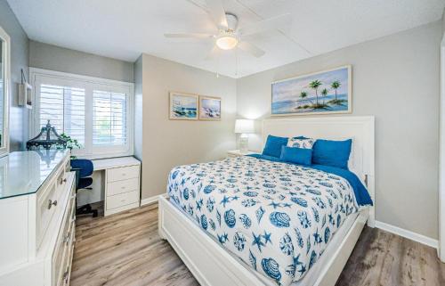 a bedroom with a bed and a dresser and a window at Beachfront Aldea 5 in Clearwater Beach